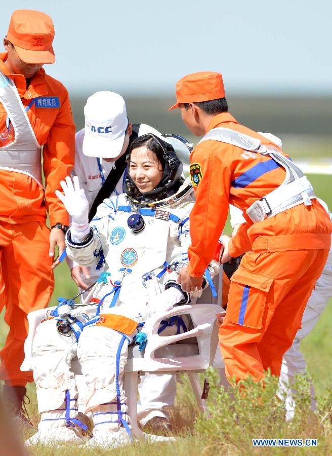 Astronaut Wang Yaping waves to people after going out of the re-entry capsule of China's Shenzhou-10 spacecraft following its successful landing at the main landing site in north China's Inner Mongolia Autonomous Region on June 26, 2013. (Xinhua/Zhang Ling) 