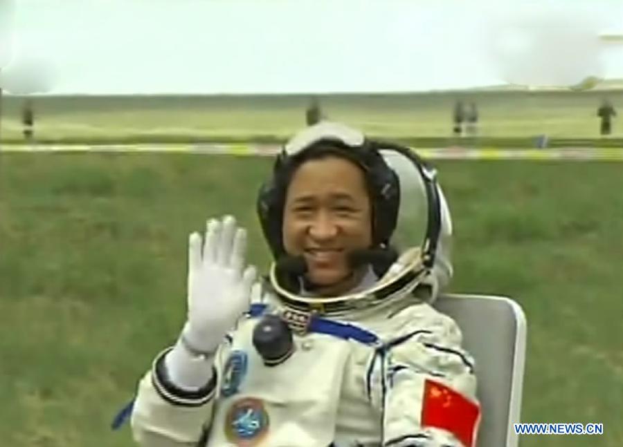 The video grab shows astronaut Nie Haisheng waves after getting out of the re-entry capsule of China's Shenzhou-10 spacecraft following its landing in north China's Inner Mongolia Autonomous Region on June 26, 2013. Commander-in-chief of China's manned space program Zhang Youxia has announced that the Shenzhou-10 mission was successful after the three crew members landed safely and left the spacecraft's re-entry module Wednesday morning. (Xinhua)