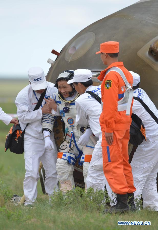 Astronaut Nie Haisheng (2nd L) gets out of the re-entry capsule of China's Shenzhou-10 spacecraft after its landing in north China's Inner Mongolia Autonomous Region on June 26, 2013. Commander-in-chief of China's manned space program Zhang Youxia has announced that the Shenzhou-10 mission was successful after the three crewmembers landed safely and left the spacecraft's re-entry module Wednesday morning. (Xinhua/Zhang Ling)