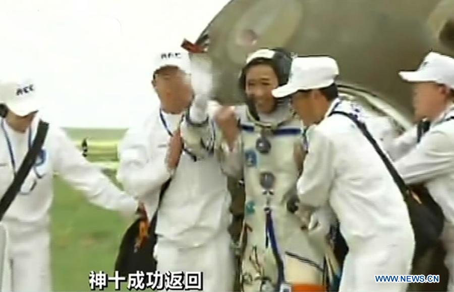 The screenshot shows astronaut Nie Haisheng (C) going out of the re-entry capsule of China's Shenzhou-10 spacecraft after its successful landing at the main landing site in north China's Inner Mongolia Autonomous Region on June 26, 2013. (Xinhua)