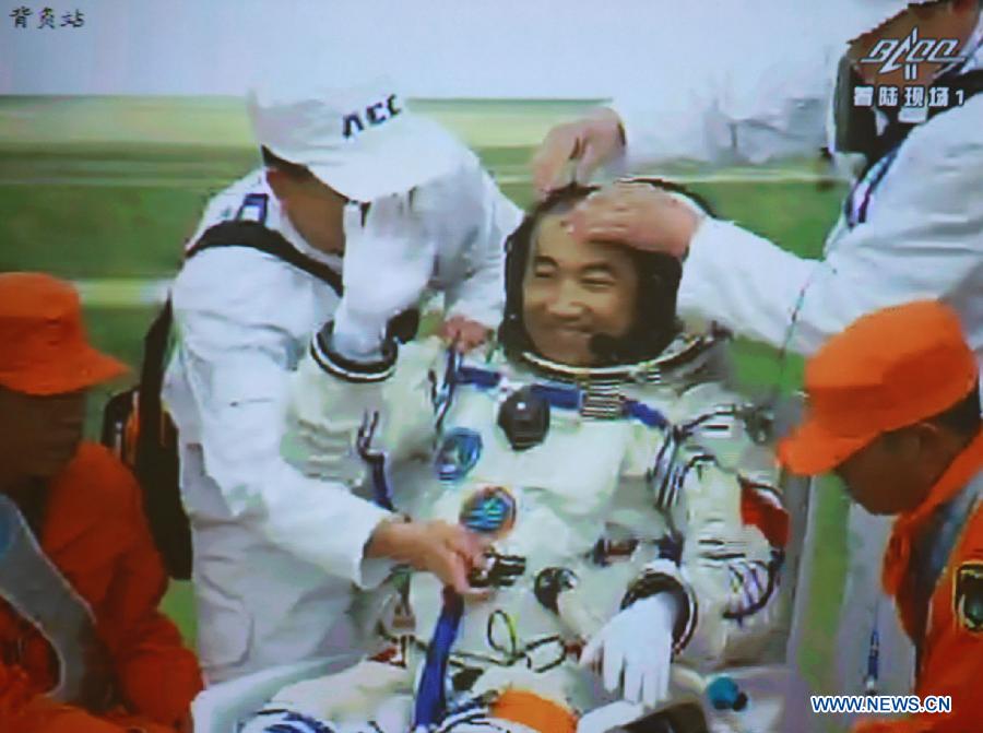 The screenshot shows astronaut Zhang Xiaoguang waving to people after going out of the re-entry capsule of China's Shenzhou-10 spacecraft following its successful landing at the main landing site in north China's Inner Mongolia Autonomous Region on June 26, 2013. (Xinhua/Wang Yongzhuo)