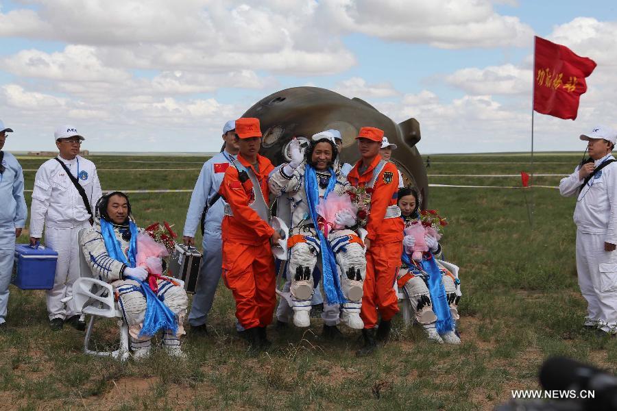 Astronauts Zhang Xiaoguang, Nie Haisheng and Wang Yaping (from left to right) are seen after they got out of the re-entry capsule of China's Shenzhou-10 spacecraft following its successful landing at the main landing site in north China's Inner Mongolia Autonomous Region on June 26, 2013. (Xinhua/Wang Jianmin)