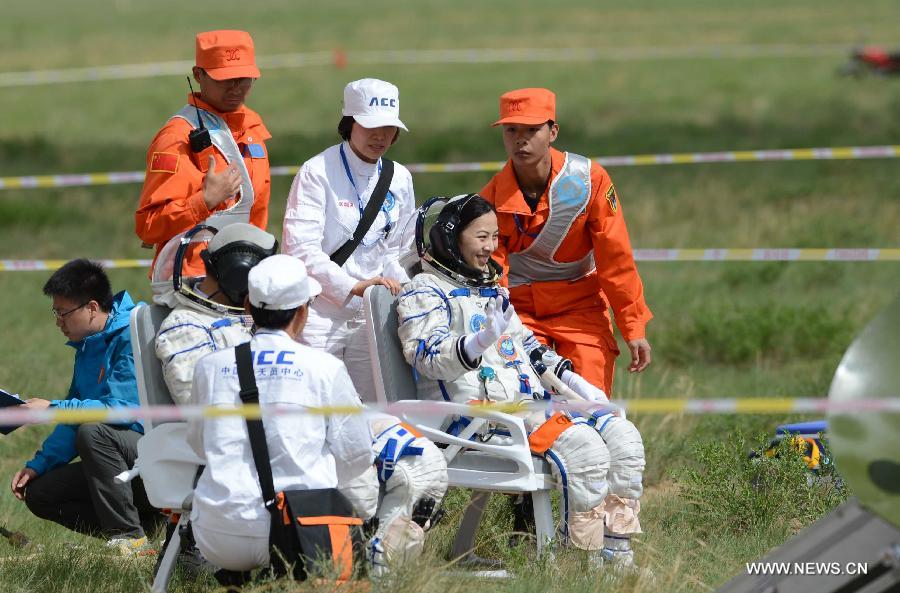 Astronaut Wang Yaping waves to people after going out of the re-entry capsule of China's Shenzhou-10 spacecraft following its successful landing at the main landing site in north China's Inner Mongolia Autonomous Region on June 26, 2013. (Xinhua/Ren Junchuan)