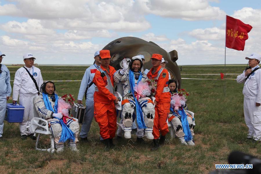 Astronauts Zhang Xiaoguang, Nie Haisheng and Wang Yaping (from left to right) are seen after they got out of the re-entry capsule of China's Shenzhou-10 spacecraft following its successful landing at the main landing site in north China's Inner Mongolia Autonomous Region on June 26, 2013. (Xinhua/Wang Jianmin)