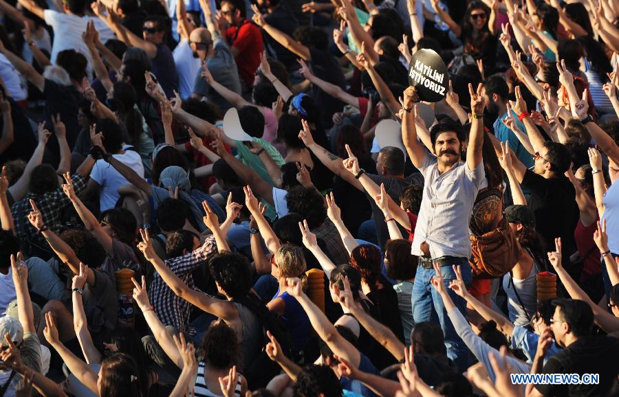 Protestors sit in front of the Taksim Square in Istanbul on June 25, 2013. Over 5,000 Turks staged a demonstration in Istanbul's iconic Taksim Square Tuesday to denounce the release of a police officer suspected of killing a protestor in Ankara. (Xinhua/Lu Zhe)