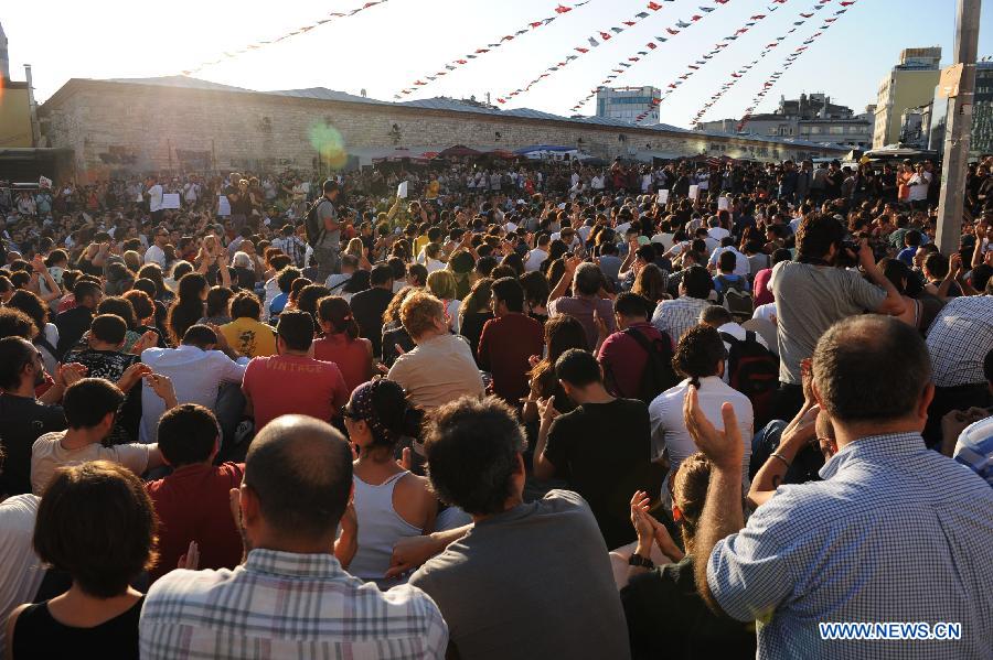 Protestors sit in front of the Taksim Square in Istanbul on June 25, 2013. Over 5,000 Turks staged a demonstration in Istanbul's iconic Taksim Square Tuesday to denounce the release of a police officer suspected of killing a protestor in Ankara. (Xinhua/Lu Zhe)