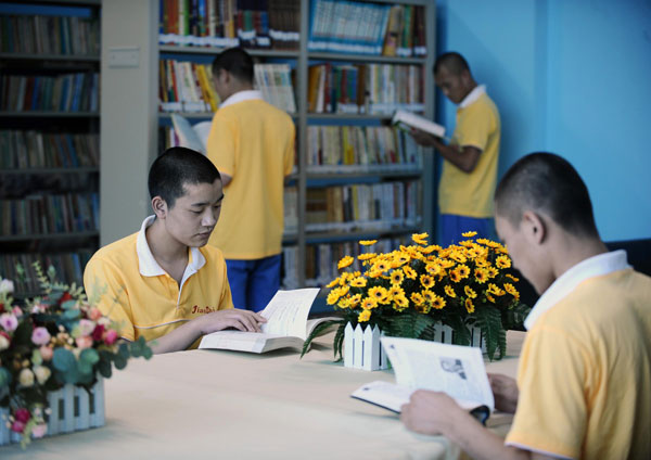 Youngsters recovering from drug addiction read books at a rehab center in Shanxi, June 13, 2013. [Photo/Xinhua]