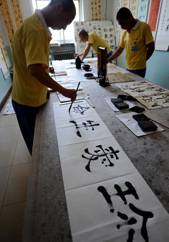 Youngsters recovering from drug addiction practice calligraphy at a rehab center in Shanxi, June 13, 2013. [Photo/Xinhua]