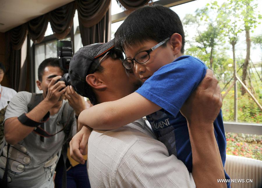 Survivor of a terror attack Zhang Jingchuan hugs his son after arriving at the airport in Kunming, capital of southwest China's Yunnan Province, June 26, 2013. Two Chinese mountaineers were among the victims killed in a pre-dawn terror attack in Pakistan-administered Kashmir on June 23. (Xinhua/Qin Lang)  