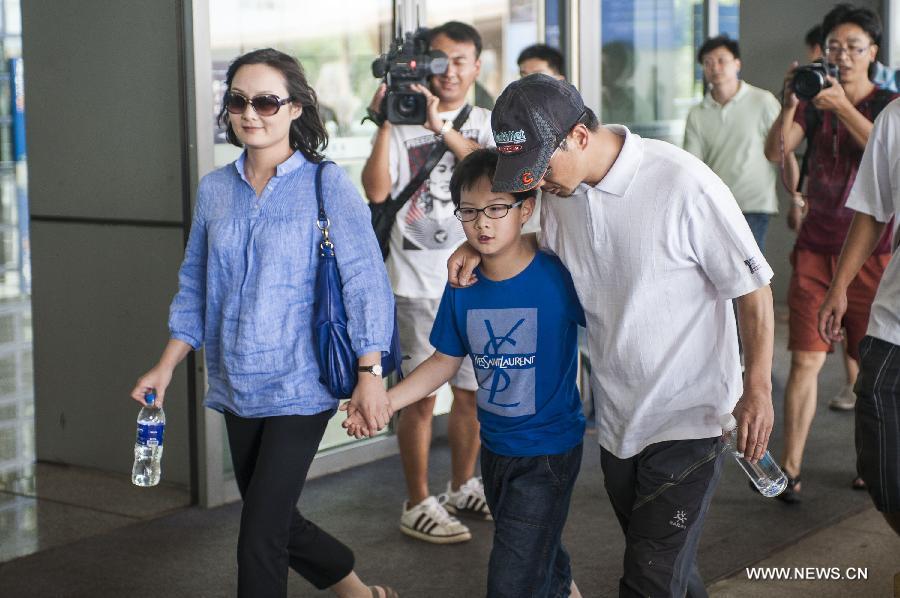 Survivor of a terror attack Zhang Jingchuan (R, front) walks with his family after arriving at the airport in Kunming, capital of southwest China's Yunnan Province, June 26, 2013. Two Chinese mountaineers were among the victims killed in a pre-dawn terror attack in Pakistan-administered Kashmir on June 23. (Xinhua/Zhang Keren)  