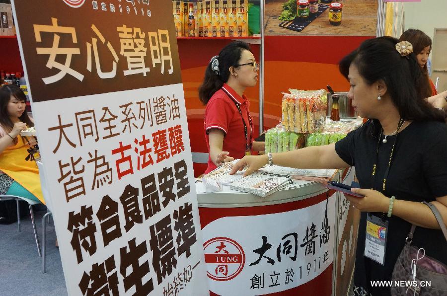 Visitors walk past a roll-up banner printed with an exhibitor's statement on food safety at Food Taipei 2013 exhibition in Taipei, southeast China's Taiwan, June 26, 2013. The four-day Food Taipei 2013 show kicked off Wednesday at Taipei World Trade Center Nangang Exhibition Hall. (Xinhua/Tao Ming)