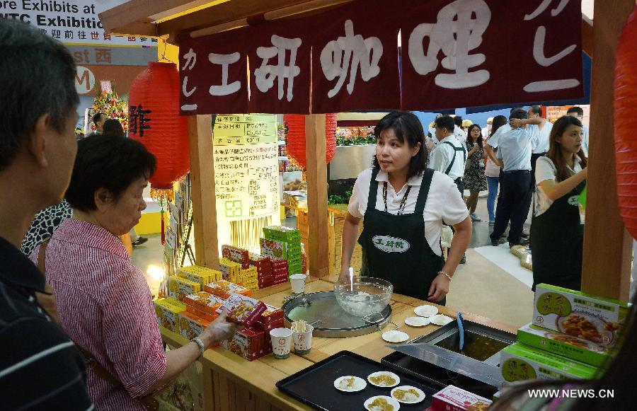 An exhibitor communicates with visitors at Food Taipei 2013 exhibition in Taipei, southeast China's Taiwan, June 26, 2013. The four-day Food Taipei 2013 show kicked off Wednesday at Taipei World Trade Center Nangang Exhibition Hall. (Xinhua/Tao Ming)