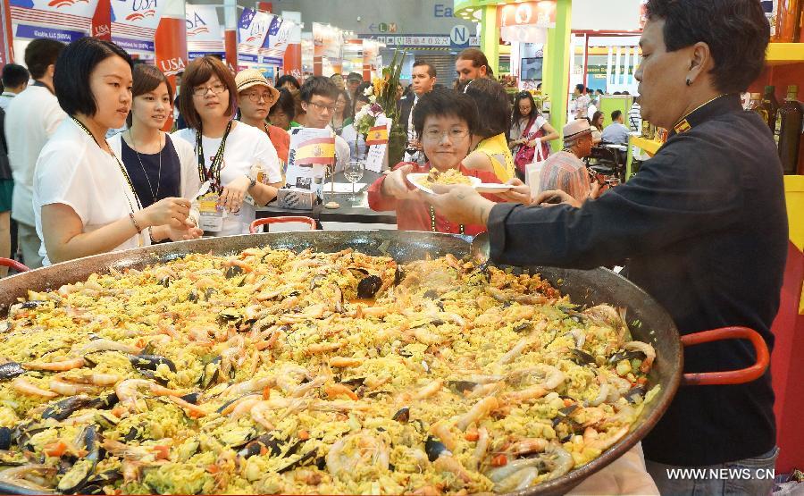 Visitors taste Spanish food at Food Taipei 2013 exhibition in Taipei, southeast China's Taiwan, June 26, 2013. The four-day Food Taipei 2013 show kicked off Wednesday at Taipei World Trade Center Nangang Exhibition Hall. (Xinhua/Tao Ming)