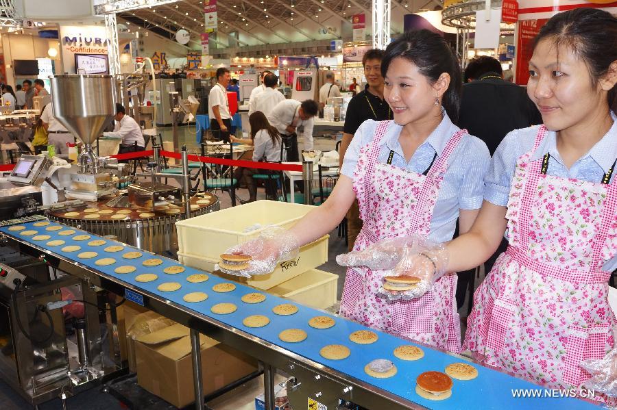 Staff members of an exhibitor make food on site at Food Taipei 2013 exhibition in Taipei, southeast China's Taiwan, June 26, 2013. The four-day Food Taipei 2013 show kicked off Wednesday at Taipei World Trade Center Nangang Exhibition Hall. (Xinhua/Tao Ming)