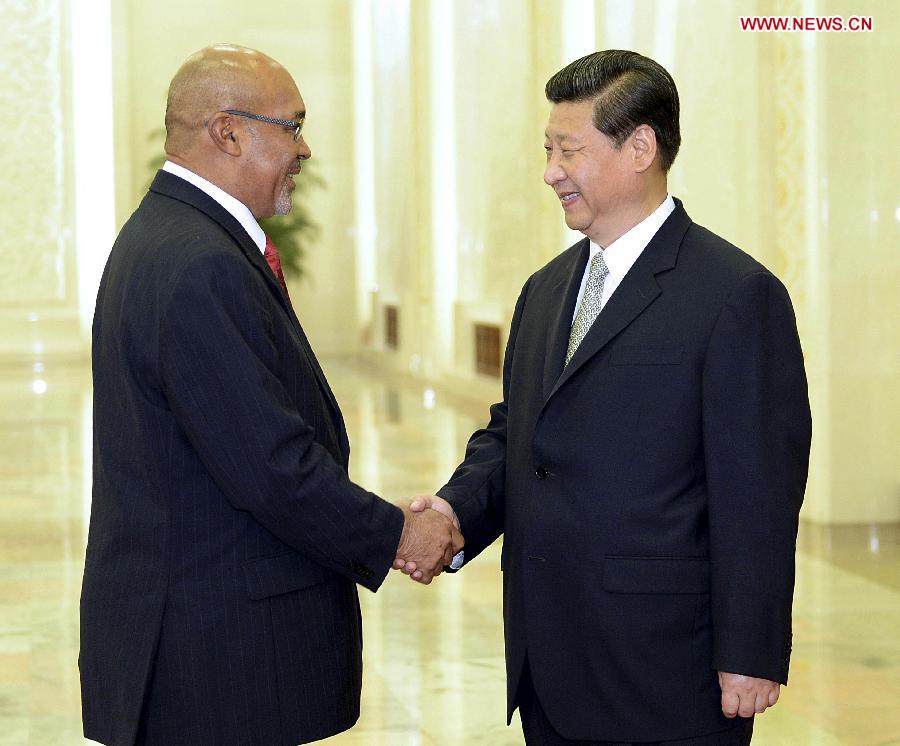 Chinese President Xi Jinping (R) shakes hands with Surinamese President Desi Bouterse who will attend the second annual World Peace Forum in Beijing, capital of China, June 26, 2013. (Xinhua/Li Tao)