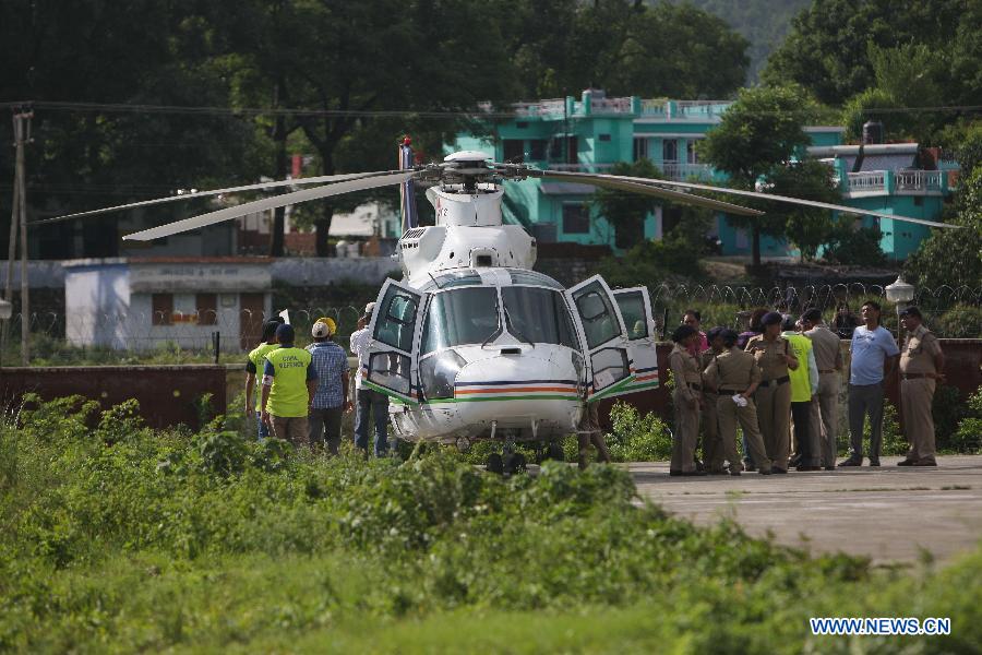Rescuers work next to a helicopter at the airport in Dehradun, northern Indian state of Uttarakhand, June 26, 2013. There are still an estimated 7000 people stranded in the flood while authorities use military planes and helicopters in the rescue in flood-ravaged northern India. (Xinhua/Zheng Huansong) 