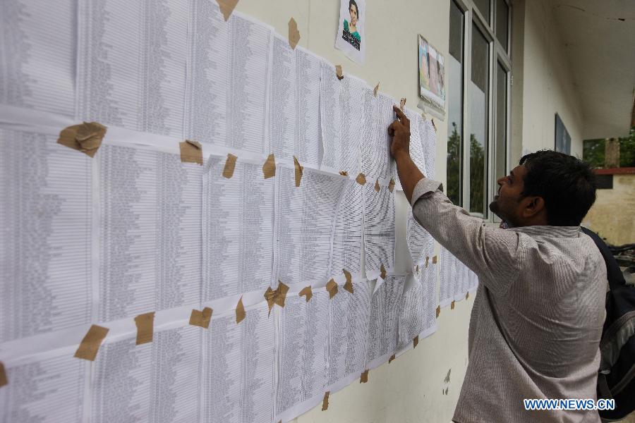 A man views information about the missing people at the helicopter airport in Dehradun, northern Indian state of Uttarakhand, June 26, 2013. There are still an estimated 7000 people stranded in the flood while authorities use military planes and helicopters in the rescue in flood-ravaged northern India. (Xinhua/Zheng Huansong)