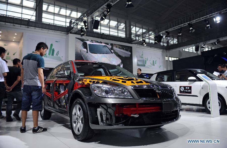 Visitors view a vehicle at the 12th Shenyang International Automobile Industry Expo in Shenyang, capital of northeast China's Liaoning Province, June 27, 2013. (Xinhua/Pan Yulong)