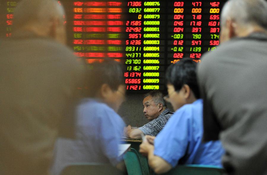 Investors look at the stock information at a trading hall of a securities firm in Nanjing, capital of east China's Jiangsu Province, June 27, 2013. Chinese shares lost a mild rebound in early morning trade and ended in negative territory on Thursday. The benchmark Shanghai Composite Index shed 0.08 percent, or 1.48 points, to end at 1,950.01. The Shenzhen Component Index shrank 0.30 percent, or 22.07 points, to 7,544.33. (Xinhua)