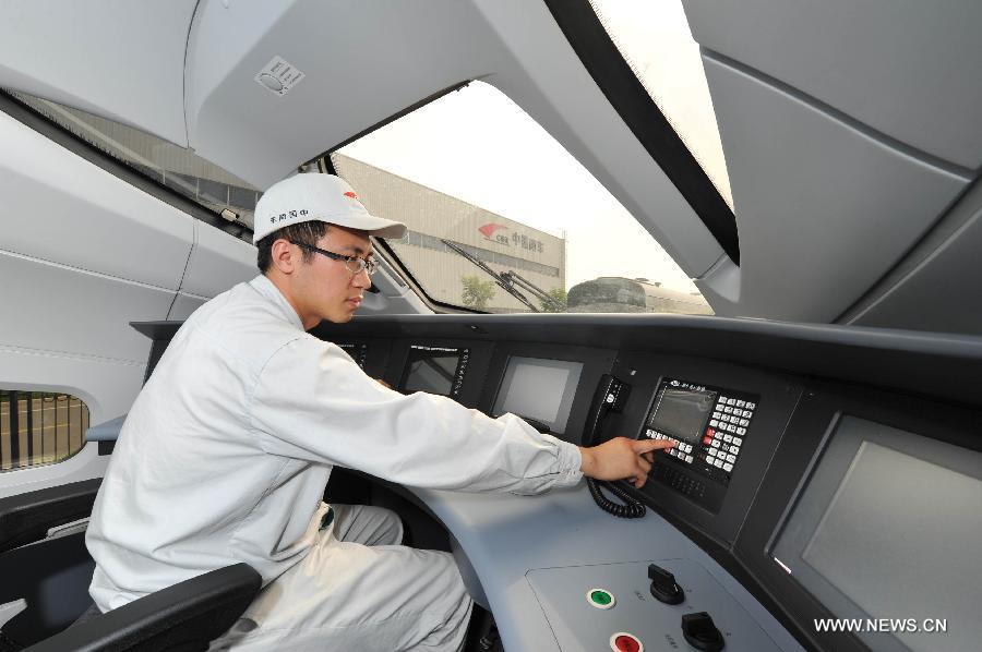 A technicist debugs the intelligent control system of China's first intelligent high-speed test train produced by CSR Qingdao Sifang Co., Ltd in Qingdao, a coastal city in east China's Shandong Province, June 27, 2013. The test train, with China Railway High-Speed (CRH) 380A train as its technical platform, is China's first large transport vehicle applied with the Internet of Things technology and sensor networks technology, through which passengers could enjoy modern information services like e-ticket and Wi-Fi. (Xinhua/Li Ziheng)