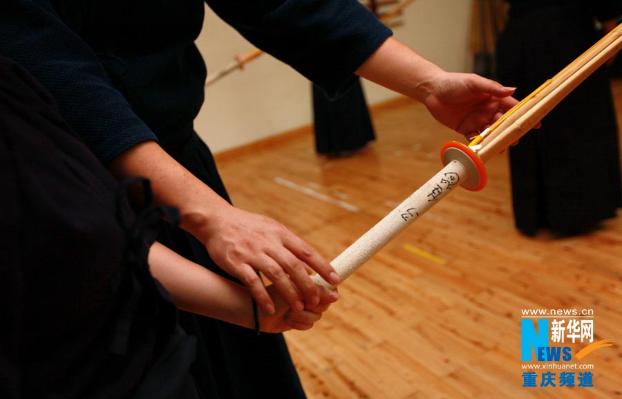 A senior fellow teaches a new learner how to hold a bamboo sword. Among these Kendo lovers, there is no relationship of teacher and students, they are senior and junior learners who exchanges experiences.  