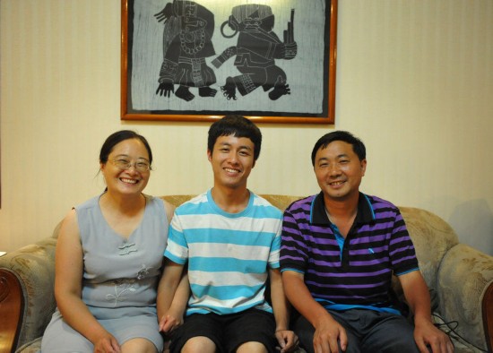 Zhou Xianku, the top scorer in science in the National College Entrance Examination in Guizhou, has picture taken with his mother and teacher.(Photo/GMW.cn)