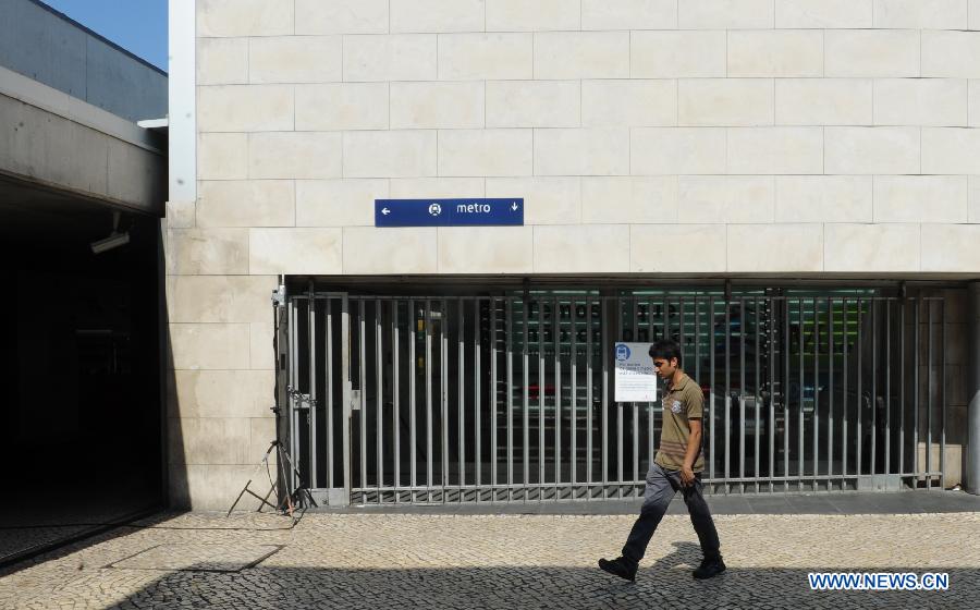 A person passes by a closed metro station in Lisbon, June 27, 2013. The Portuguese staged a general strike across the country on Thursday fuelled by the prolonged economic recession in the bailed-out country. Meanwhile, thousands of Portuguese in Lisbon took to the street protesting against the government's austerity measures. (Xinhua/Zhang Liyun) 