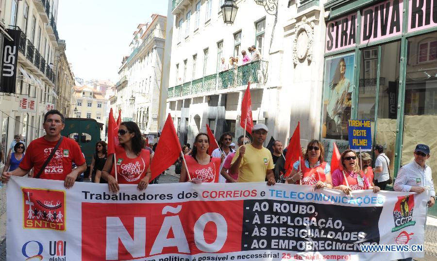People participate in a protest against the government's austerity measures in Lisbon, June 27, 2013. The Portuguese staged a general strike across the country on Thursday fuelled by the prolonged economic recession in the bailed-out country. Meanwhile, thousands of Portuguese in Lisbon took to the street protesting against the government's austerity measures. (Xinhua/Zhang Liyun)
