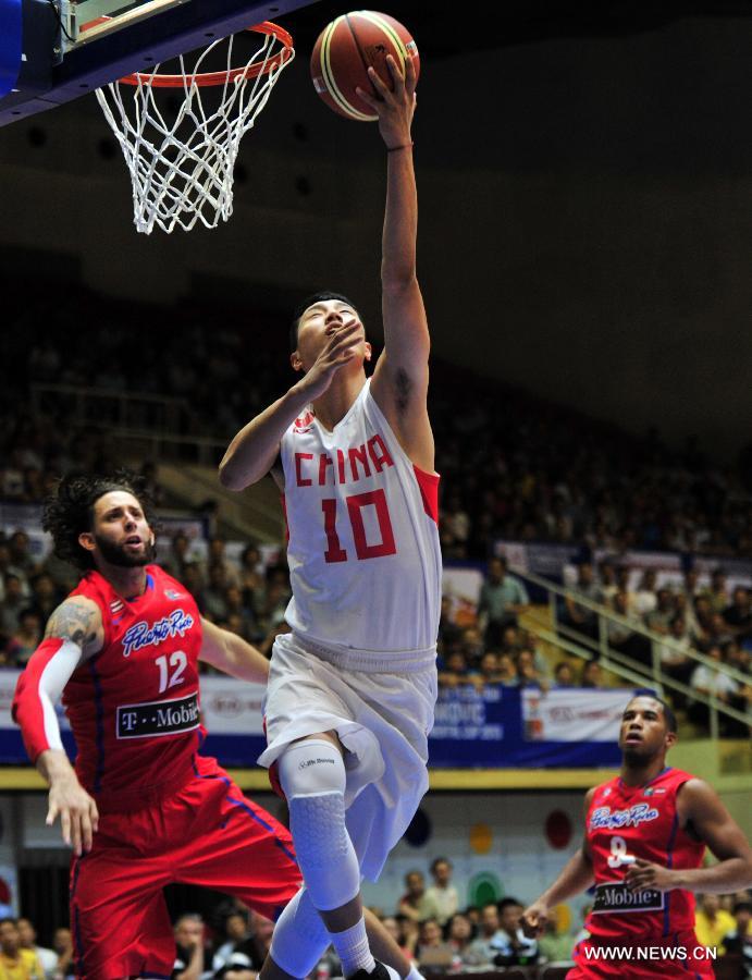 Zhai Xiaochuan (R) of China goes for basket past Carlos Lopez of Puerto Rico during a match at the Stankovic Continental Cup 2013 in Lanzhou, northwest China's Gansu Province, June 27, 2013. China won the match 79-67. (Xinhua/Chen Bin)