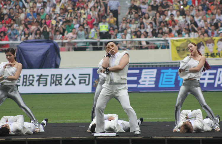Passionate dance: South Korean singer Psy performs during a charity soccer match between the Park Ji-sung and Friends team and Shanghai Laokele Stars at the Shanghai Hongkou Stadium in Shanghai, June 23, 2013. (Photo/Osports)
