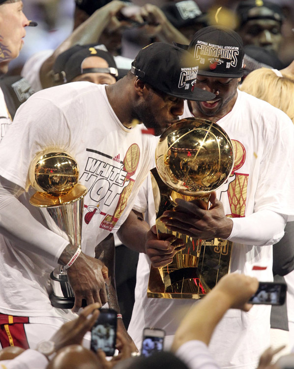The most glorious moments: LeBron James (L) of Miami Heat kisses the Larry O'Brien Championship Trophy after the game 7 of the NBA finals against San Antonio Spurs in Miami, U.S., on June 20, 2013. Heat defeated Spurs 95-88 and won the champion. (Photo/Osports)