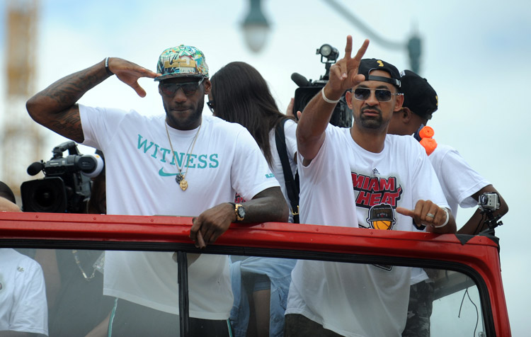 The Heat hold their grand parade. LeBron James stands atop a double-decker bus and salutes the fans. (Photo/Osports)