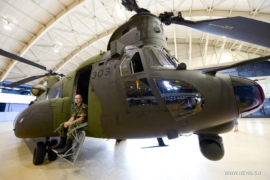 A soldier sits on a new CH-147F Chinook helicopter during the unveiling ceremony in Ottawa June 27, 2013. The 15 newly purchased F-model Chinooks will be engaged in support, domestic and foreign operations for the Royal Canadian Air Force's reactivated "450 Tactical Helicopter Squadron" based in Petawawa, Ontario. (Xinhua/James Park)