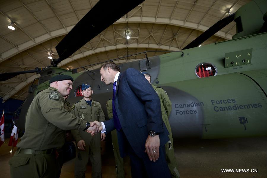 Canadian Defense Minister Peter MacKay (R) shakes hands with a pilot from the Royal Canadian Air Force during the unveiling of new CH-147F Chinook helicopters in Ottawa June 27, 2013. The 15 newly purchased F-model Chinooks will be engaged in support, domestic and foreign operations for the Royal Canadian Air Force's reactivated "450 Tactical Helicopter Squadron" based in Petawawa, Ontario. (Xinhua/James Park)