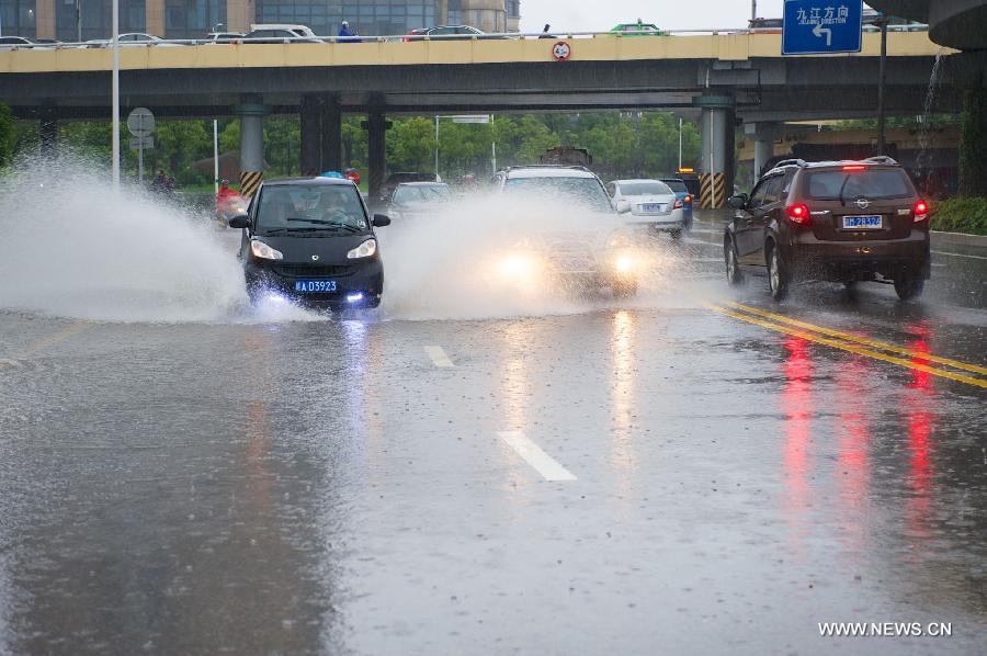 Vehicles run on a waterlogged road in rain in Nanchang, capital of east China's Jiangxi Province, June 28, 2013. Heavy rainfall hit parts of the province on Friday. (Xinhua/Hu Chenhuan) 