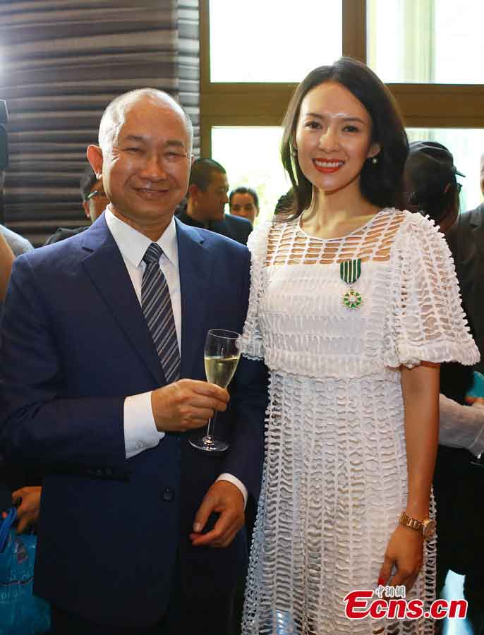 Zhang Ziyi takes a photo with John Woo Yu-Sen, a Hong Kong film director, after she was awarded the Order of Arts and Letters by the French government in Beijing, capital of China, June 27, 2013. Established in 1957, the order is the recognition of significant contributions to the arts and literature. (CNS/Li Xueshi)