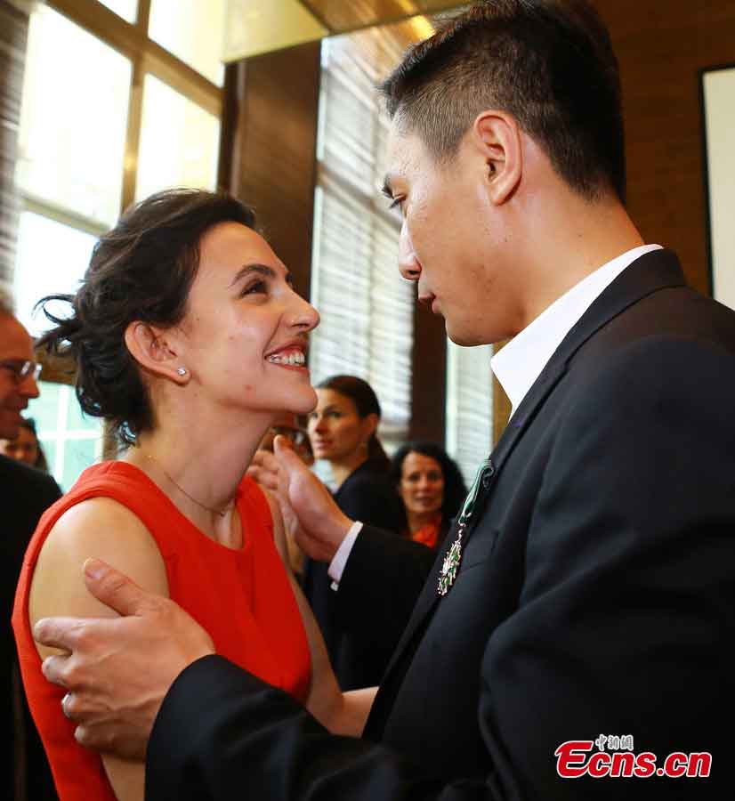 Liu Ye kisses his wife after he was awarded the Order of Arts and Letters by the French government in Beijing, capital of China, June 27, 2013. Established in 1957, the order is the recognition of significant contributions to the arts and literature. (CNS/Li Xueshi)