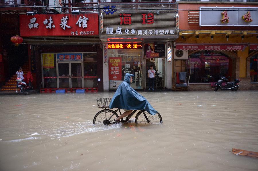 A citizen rides bicycle on a flooded road in Nanchang, capital of east China's Jiangxi Province, June 28, 2013. Heavy rainfall hit the city on Friday. (Xinhua/Zhou Mi) 