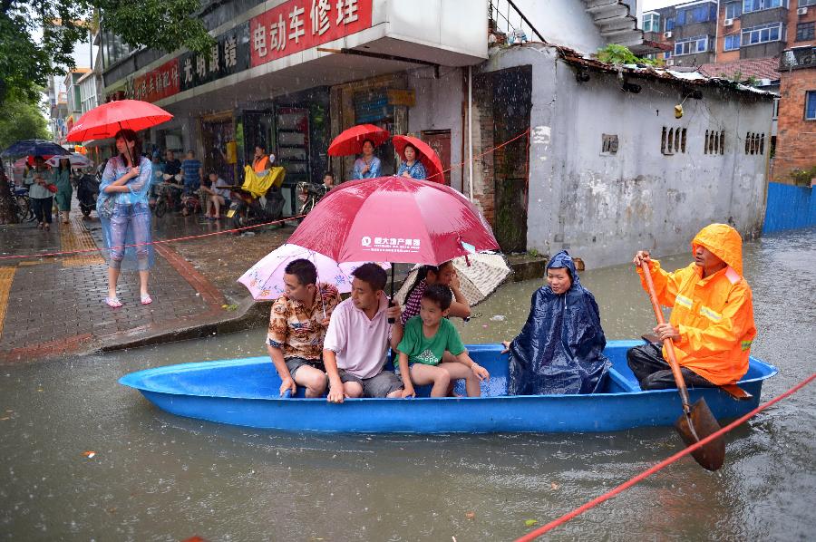Residents are transferred by taking a boat on a flooded road in Nanchang, capital of east China's Jiangxi Province, June 28, 2013. Heavy rainfall hit the city on Friday. (Xinhua/Zhou Mi) 