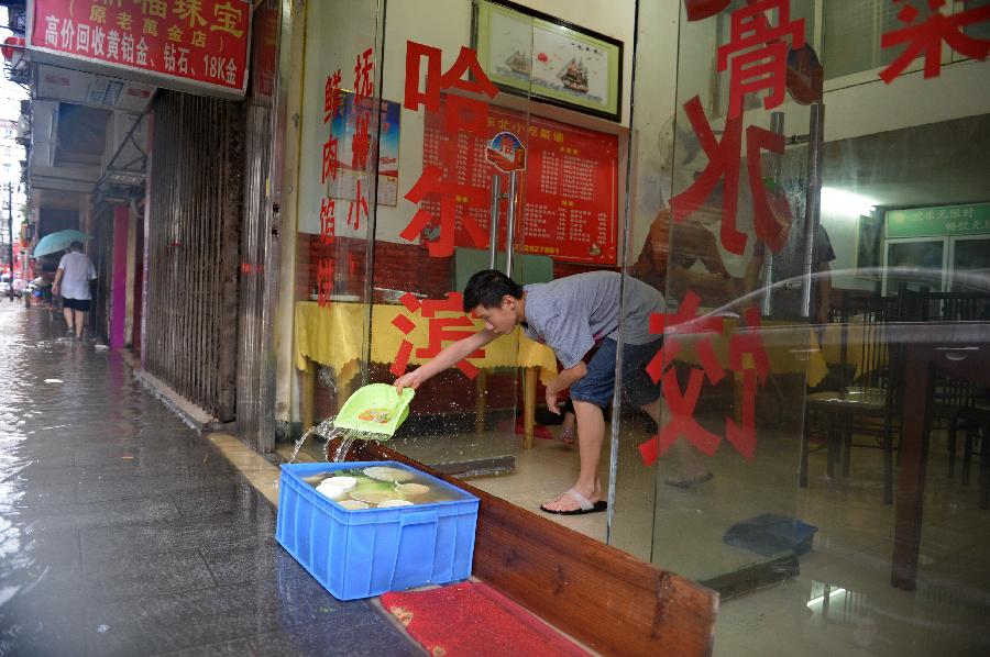 A worker clears water from a flooded restaurant in Nanchang, capital of east China's Jiangxi Province, June 28, 2013. Heavy rainfall hit the city on Friday. (Xinhua/Zhou Mi) 