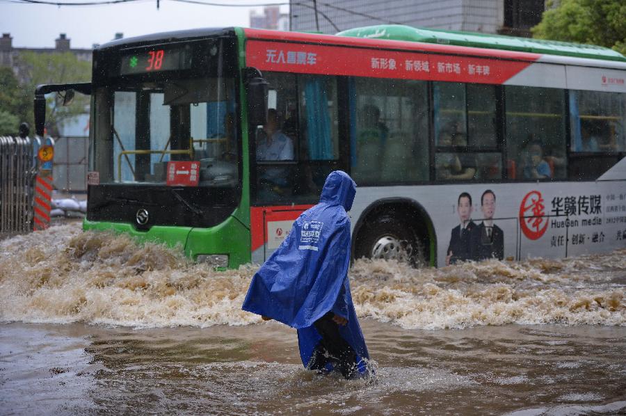 A pedestrian walks on a flooded road in Nanchang, capital of east China's Jiangxi Province, June 28, 2013. Heavy rainfall hit the city on Friday. (Xinhua/Zhou Mi) 