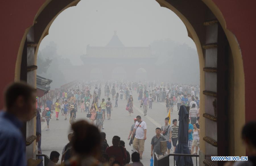 People visit the Temple of Heaven in haze in Beijing, capital of China, June 28, 2013. Most parts of Beijing are shrouded by severe haze on Friday. (Xinhua/Wang Qingqin)