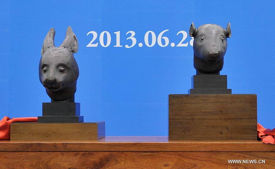 Photo taken on June 28, 2013 shows two bronze animal head sculptures plundered by western invaders one-and-a-half centuries ago at a handover ceremony of the heads in Beijing, capital of China. The heads of a rat and a rabbit, parts of a fountain clock that previously stood at the Old Summer Palace, or "Yuanmingyuan" in Chinese, were donated on April 26, 2013 by the Pinault family, which owns the French luxury brand Kering. The handover ceremony was held Friday at National Museum of China. (Xinhua/Li Xin) 