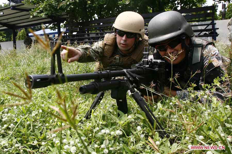 A U.S. navy soldier (L) instructs his Philippine counterpart during a joint military exercises between the Philippines and the United States at the South China Sea, June 28, 2013. The Philippines and U.S. Naval forces began joint military exercises codenamed Cooperation Afloat Readiness and Training (CARAT) at the South China Sea on June 27 to enhance the capability of both sides through practical exercises and lectures. (Xinhua/Rouelle Umali) 