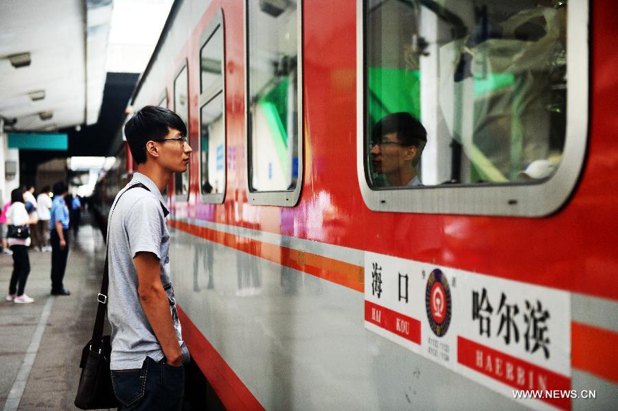 A man sees his girlfriend off outside the K1124 train from northeast China's Harbin to south China's Haikou in Harbin, capital of northeast China's Heilongjiang Province, June 28, 2013. The train which travels 4,458 kilometers for 65 hours has connected China's northernmost capital city Harbin of Heilongjiang Province with southernmost capital city Haikou of Hainan Province. (Xinhua/Wang Kai) 