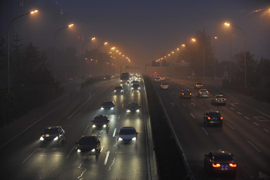Vehicles move in haze in Beijing, capital of China, June 28, 2013. Most parts of Beijing are shrouded by severe haze on Friday. (Xinhua/Song Weiwei)