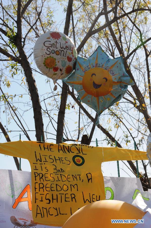 Balloons, placard, T-shirt with best wishes for South Africa's anti-apartheid icon Nelson Mandela are seen outside the hospital where Mandela gets medical treatment in Pretoria, South Africa, on June 28, 2013. Mandela's condition continues to improve, Mandela's ex-wife Winnie Madikizela-Mandela said on Friday. (Xinhua/Guo Xinghua) 
