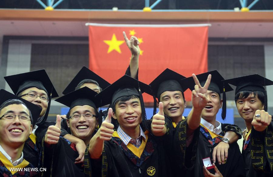Graduates pose for a group photo during the graduation ceremony of Zhejiang University in Hangzhou, capital of east China's Zhejiang Province, June 29, 2013. The graduation ceremony was held here Saturday. (Xinhua/Han Chuanhao)