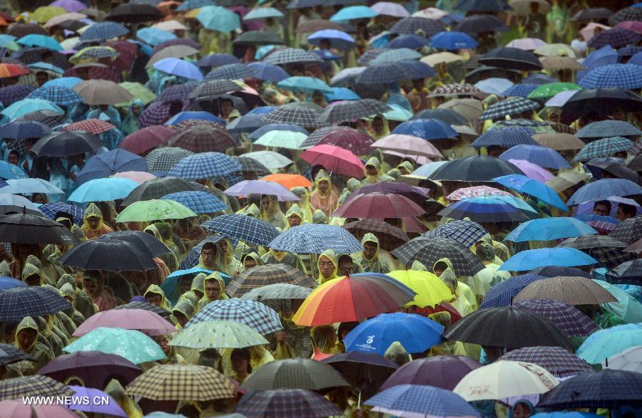 Graduates attend the graduation ceremony of Zhejiang University in the rain in Hangzhou, capital of east China's Zhejiang Province, June 29, 2013. The graduation ceremony was held here Saturday. (Xinhua/Han Chuanhao)
