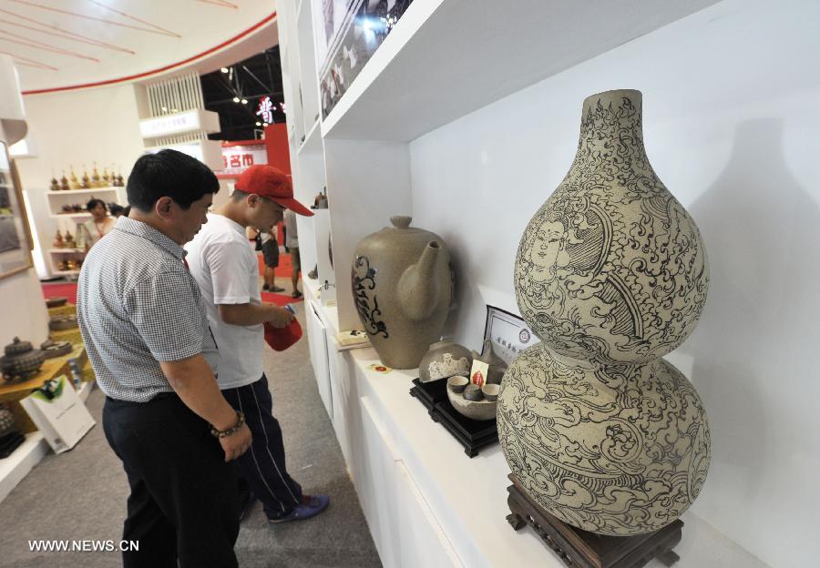 Visitors look at pottery artworks from Pingding County during the 1st Shanxi Cultural Industry Expo in Taiyuan, capital of north China's Shanxi Province, June 29, 2013. The exhibition will last till July 3. (Xinhua/Yan Yan)